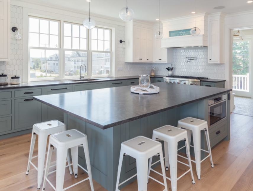 Modern kitchen with Black Mist Honed granite countertops, featuring a large island and white cabinetry